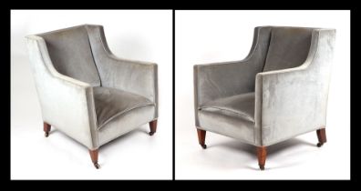 A pair of Edwardian upholstered tub armchairs on tapering mahogany square legs terminating in