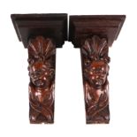 A pair of carved oak wall brackets in the form of cherubs with shelf above, 28cms high (2).