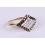 A 9ct gold dress ring set with black and white diamonds, approx UK size 'P', 2.6g.