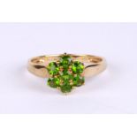 A 9ct gold dress ring set with bright green stones, approx UK size 'O', 2.3g.