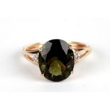 A 9ct gold ring set with a large oval dark green stone and diamond set shoulders, approx UK size '