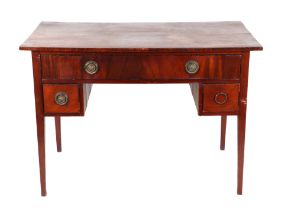 An Edwardian walnut kneehole desk, the central drawer flanked by two cupboards, on tapering fluted