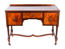 An Edwardian walnut dressing table with an arrangement of three drawers, on reeded tapering legs,