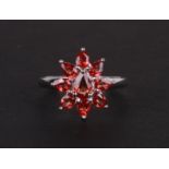 A 9ct white gold cluster ring set with pale red stones, approx UK size 'O', 2.6g.
