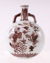 A Chinese red and white moon flask decorated with phoenix amongst clouds, four character mark to the