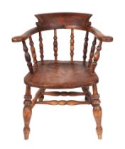 A Smoker's Bow armchair with solid elm seat on turned front legs joined an 'H' stretcher.