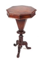 A Victorian walnut trumpet sewing work table, the octagonal top opening to reveal a fitted interior,