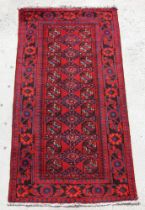 A Persian Turkoman hand knotted runner with repeat geometric design, on a red ground, 230 by