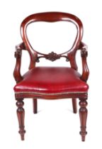 A Victorian mahogany balloon back open armchair with overstuffed seat and baluster reeded front