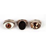 Three silver rings to include a Georgian style ring with intaglio, another with a glass eye and