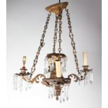 A gilt metal four-branch ceiling light with prismatic drops.