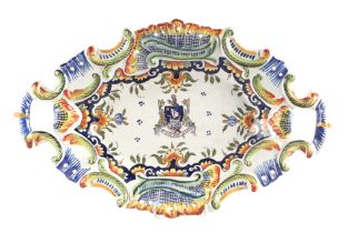 A French faience two-handled dish with central armorial decoration, 40cms wide.