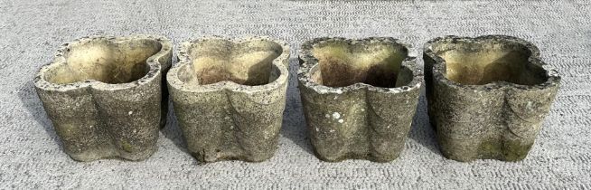 A set of four well weathered reconstituted stone lobed form planters, 32cms wide; together with a