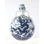 A Chinese blue & white moon flask decorated with dragons amongst clouds, 31cms high.