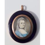 A 19th century portrait miniature on ivory, a woman wearing a veil within a yellow metal and blue