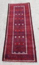 A Persian Balouch hand knotted woollen runner with repeat medallions within geometric borders, 275