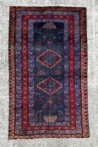 A Persian hand knotted woollen Hamadan rug decorated with stylised animals and vases of flowers,