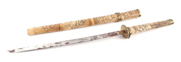 A late 19th century Japanese carved bone short sword or Wakizashi, carved all over with figures.