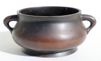 A Chinese two-handled bronze censer with six character mark to the underside, 16cms diameter.