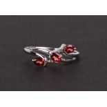 A 9ct white gold dress ring set with three pale red stones and two diamonds, approx UK size 'P', 1.