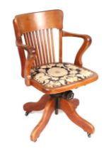 An early 20th century oak revolving desk chair by Cooke's of Finsbury.