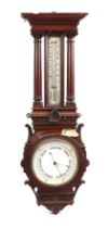 An Edwardian aneroid barometer and thermometer in a carved oak case, 92cms high.