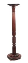 A Victorian carved oak torchere with fluted column and stepped circular base, 142cms high.