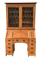 An early 20th century 'The Britisher' desk constructed from oak, the bookcase with cornice and