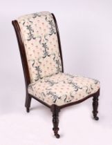 A Victorian nursing chair with upholstered seat and back, on turned front supports.