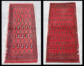 Two small Persian Turkoman woollen hand-made rugs with geometric designs on a red ground, each