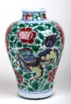 A Chinese famille verte baluster vase decorated with shishi and prunus, 19cms high Condition