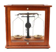 A set of chemist's scales in a glazed oak case.