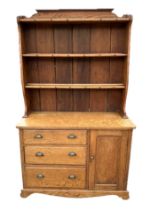 An oak cottage dresser, the shaped plate rack above three long drawers and a cupboard, 120cms wide.