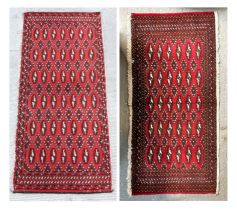 Two small Persian Turkoman woollen hand-made rugs with geometric designs on a red ground, each