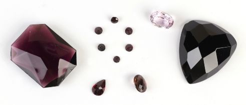 A quantity of loose gem stones, mainly amethyst coloured.