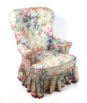 A Victorian style button back armchair on turned front supports.