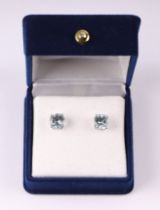 A pair of 9ct white gold stud earrings set with pale blue stones, possibly blue topaz.