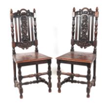 A pair of 16th century style oak chairs with carved back splats, solid seats and turned legs