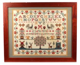 A 19th century style cross stitch sampler with alphabet, numbers and animals within a wavy foliate