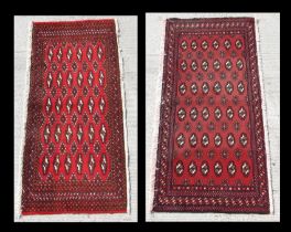 Two small Persian Turkoman woollen hand-made rugs with geometric designs on a red ground, each