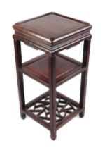 A Chinese hardwood three-tier vase stand or side table, 38cms wide.