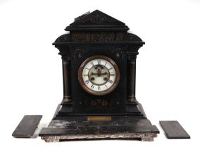 A Victorian architectural black slate mantle clock, the white enamel dial with open escarpment and