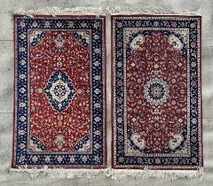 A modern Persian rug decorated with foliate scrolls, on a red ground; together with another