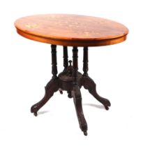 A late Victorian or Edwardian inlaid walnut occasional table on a carved quatrefoil base, 90cms