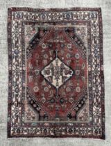 A Persian hand knotted woollen Hamadan rug, the central gul within a stylised floral border, on a