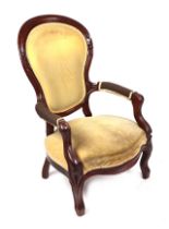 A Victorian armchair with upholstered seat and back.