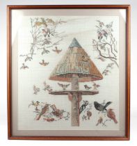 A 20th century cross stitch embroidered panel depicting woodland birds on a bird feeder, framed &