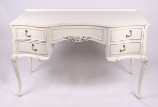 A gilt and white painted kneehole dressing table with for short drawers, on cabriole legs, 122cms