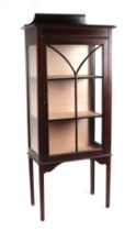 An Edwardian mahogany display cabinet, the astragal glazed panelled door enclosing a shelved