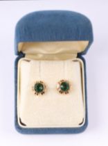 A pair of 9ct gold stud earrings set with a large green stone.